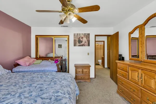 a bedroom with a bed dresser and a large window