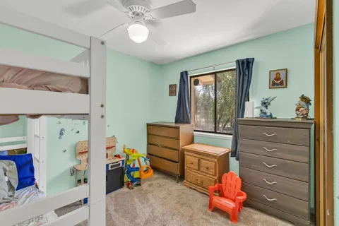 a room with a baby bed baby crib and dresser