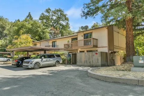 a front view of a house with a yard and parking