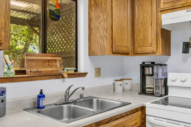 a kitchen with granite countertop a sink and a wooden cabinets