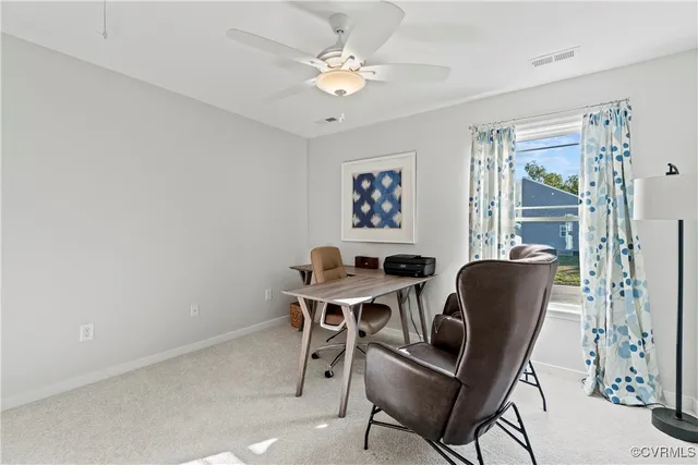 a view of a workspace with furniture and a window