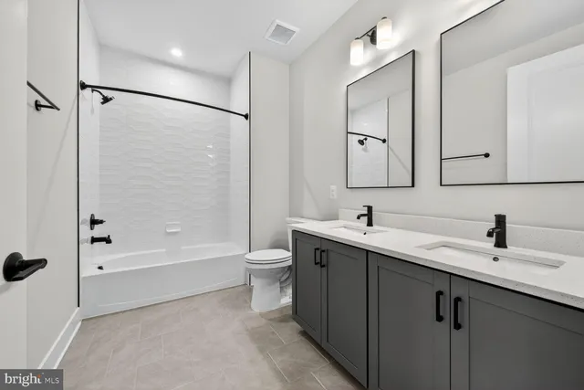 a bathroom with a bathtub shower sink vanity and toilet