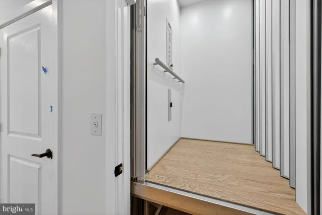 a view of a hallway with closet and wooden floor