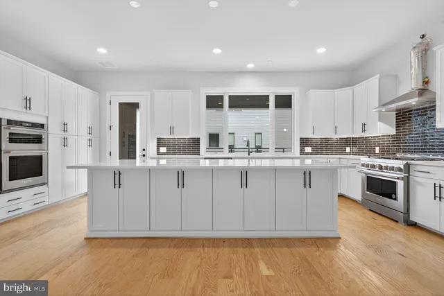 a kitchen with stainless steel appliances granite countertop a stove a sink and a refrigerator