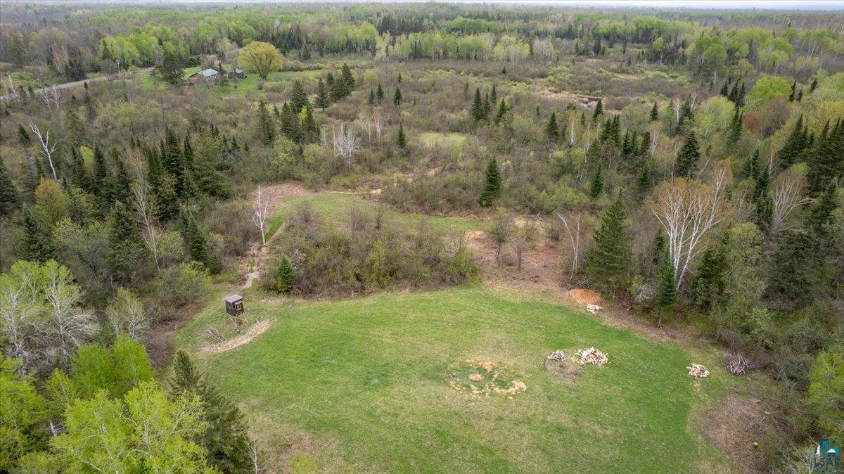 5190 County Road M Gordon, WI 54838 - Photo 28 of 31 Expansive acreage featuring a clearing of green grass, surrounded by mature trees, and a small elevated structure