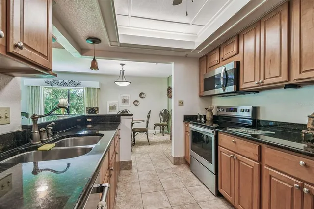 a kitchen with stainless steel appliances granite countertop a sink stove and cabinets
