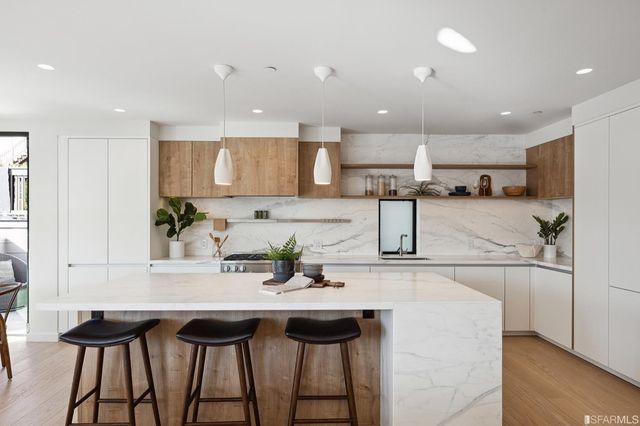 a kitchen with stainless steel appliances kitchen island granite countertop a table and chairs in it