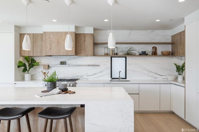 a kitchen with kitchen island a stove and a sink