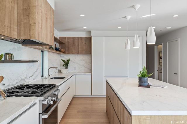 a kitchen with stainless steel appliances granite countertop a sink stove and cabinets