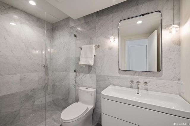 a bathroom with a toilet sink shower and mirror