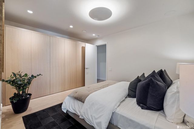 a bedroom with a bed and a potted plant