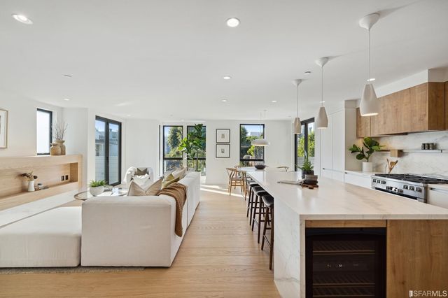 a view of kitchen with stainless steel appliances granite countertop a stove and a sink