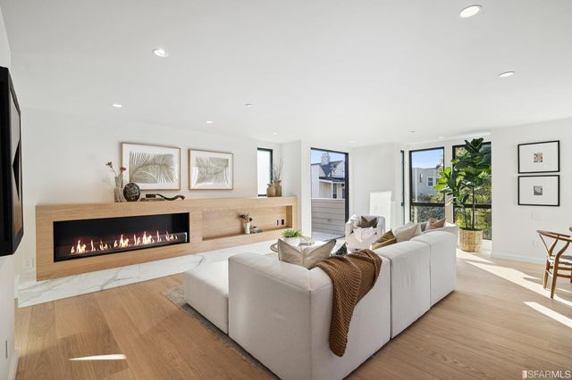 a living room with furniture a fireplace and a table