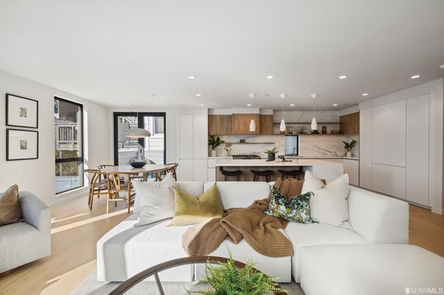 a living room with furniture and kitchen view