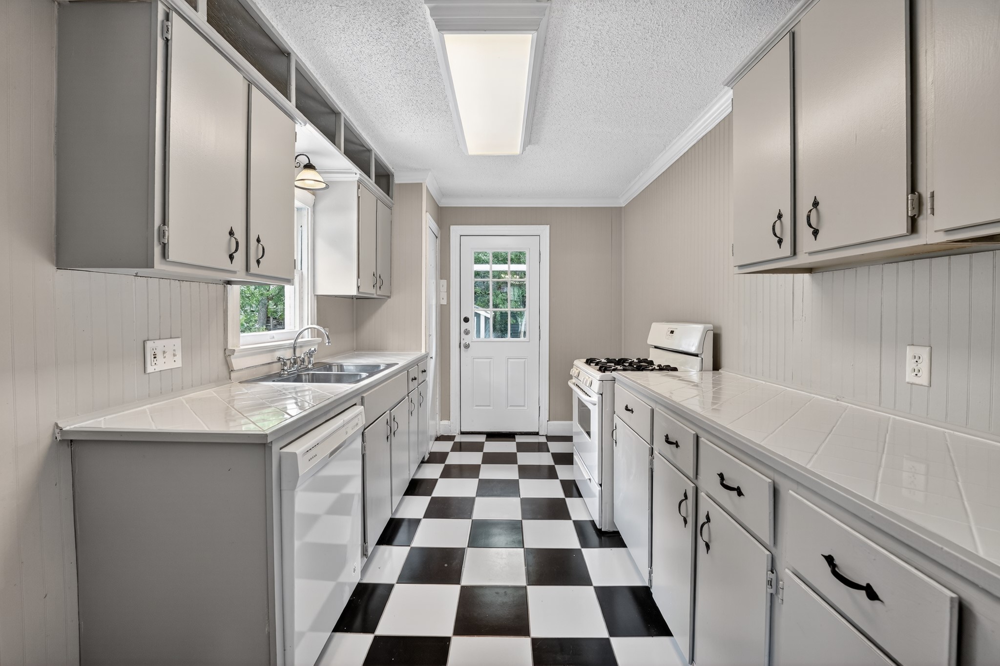 4907 Duval Street Austin, TX 78751 - Photo 9 of 31 a kitchen with a sink a refrigerator and cabinets
