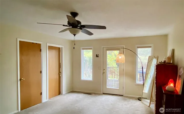 a view of empty room with wooden floor and fan