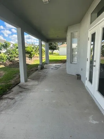 a view of an empty room with a floor to ceiling window and a yard
