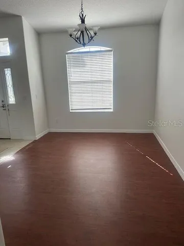 an empty room with a window and wooden floor
