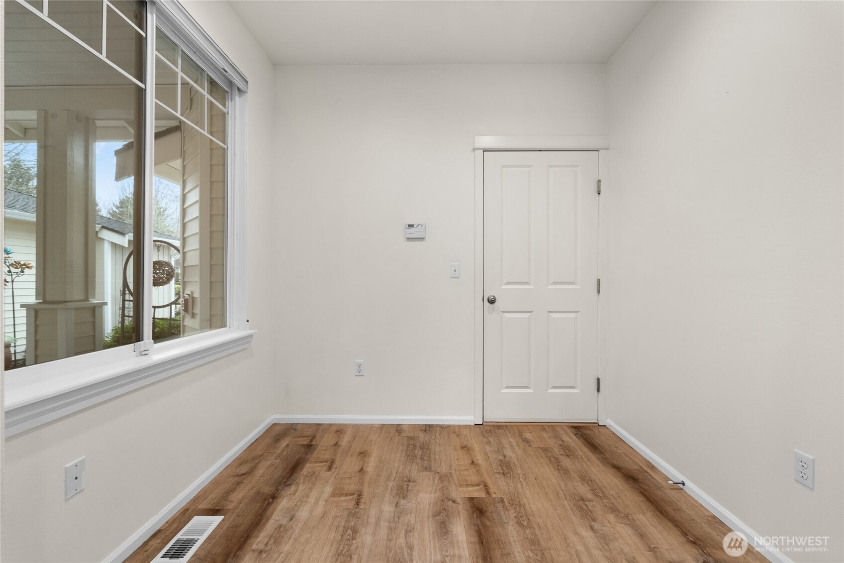 18708 109 Lane Southeast, Unit K30 Renton, WA 98055 - Photo 23 of 36 a view of an empty room with wooden floor and a window