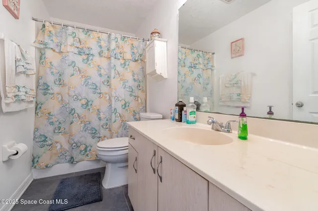 a bathroom with a sink a toilet and shower curtain
