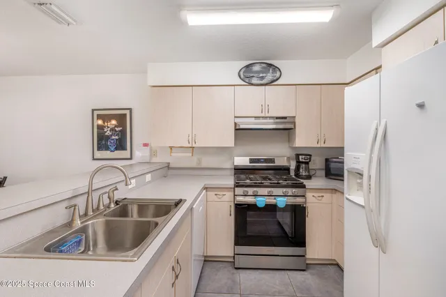 a kitchen with stainless steel appliances a stove a sink and a refrigerator