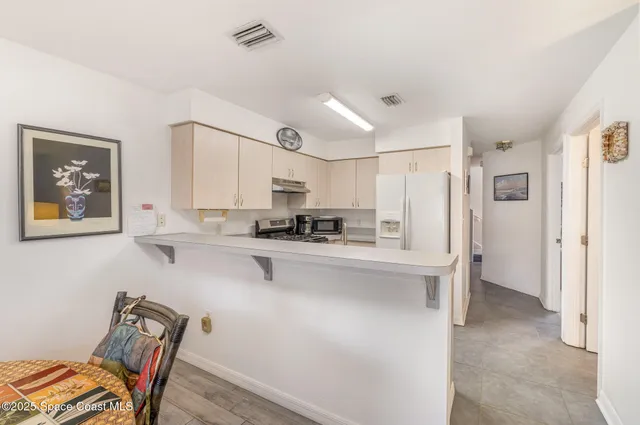 a kitchen with stainless steel appliances a refrigerator and a cabinets