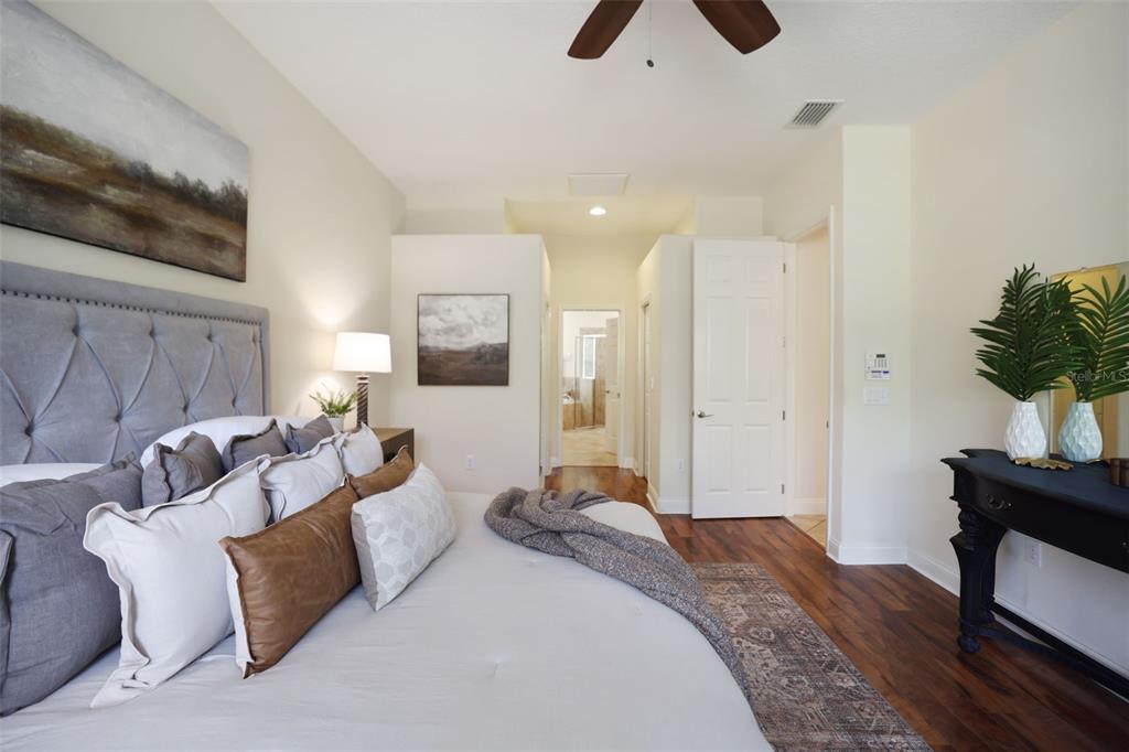 27211 Hawks Nest Circle Wesley Chapel, FL 33544 - Photo 25 of 58 a spacious bedroom with a bed and a chandelier