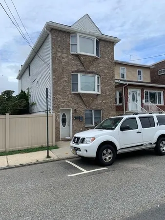a car parked in front of a brick house