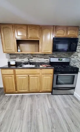 a stove top oven sitting inside of a kitchen