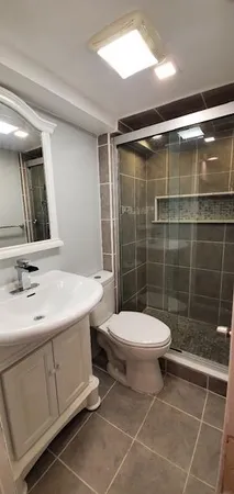 a bathroom with a sink a toilet and shower