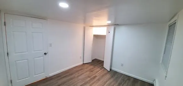 a view of an empty room with wooden floor