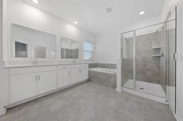 a spacious bathroom with a shower a sink and mirror