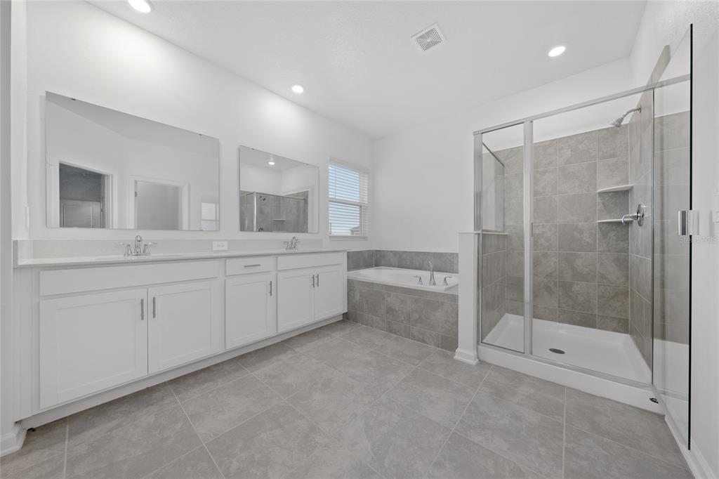 6061 Shavasana Road Clermont, FL 34714 - Photo 17 of 33 a spacious bathroom with a shower a sink and mirror