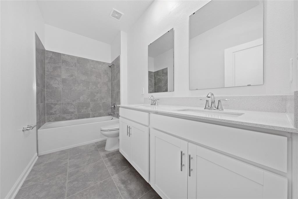 6061 Shavasana Road Clermont, FL 34714 - Photo 22 of 33 a bathroom with a tub sink toilet and a mirror