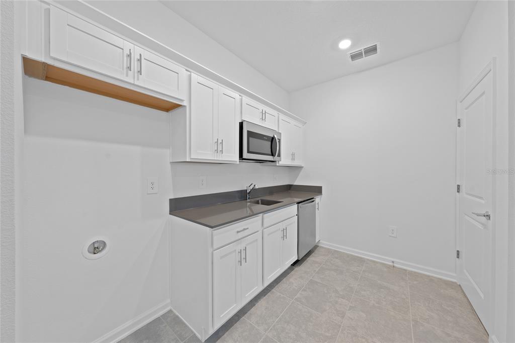6061 Shavasana Road Clermont, FL 34714 - Photo 29 of 33 a kitchen with granite countertop a sink and a stove top oven