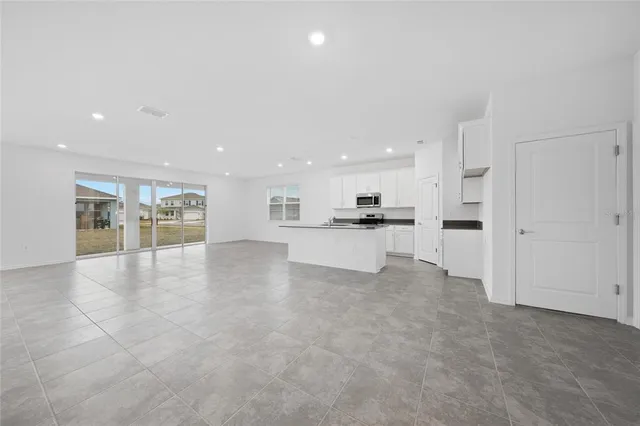 a view of kitchen with kitchen island and stainless steel appliances