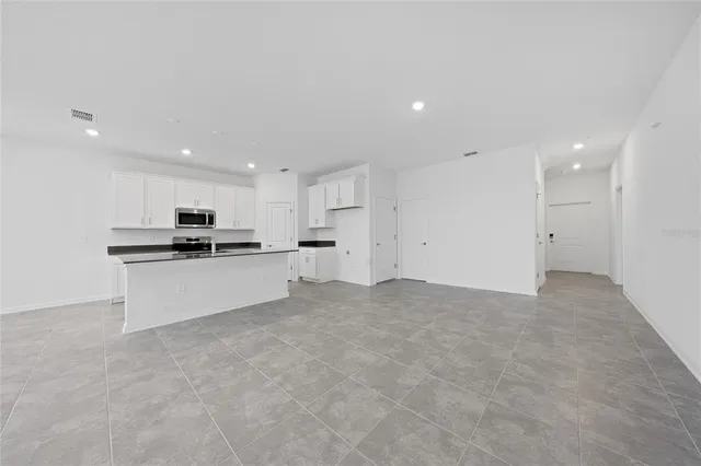 a view of kitchen with kitchen island a sink stainless steel appliances and cabinets