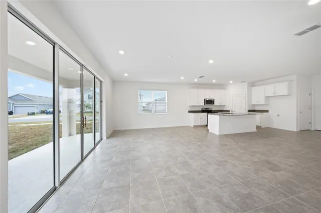 a view of kitchen with stainless steel appliances refrigerator oven and cabinets