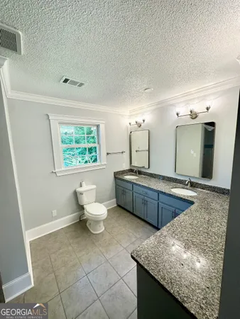 a large bathroom with a granite countertop sink and a mirror
