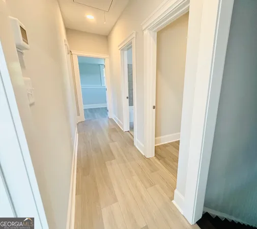 a view of a hallway with wooden floor