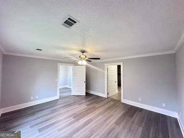 a view of an empty room with wooden floor
