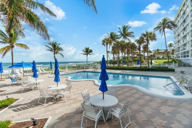 a swimming pool with outdoor seating and a patio