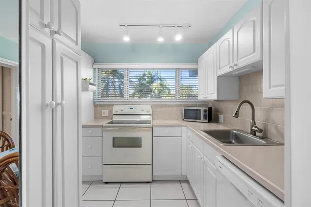 a kitchen with stainless steel appliances granite countertop a sink and a refrigerator
