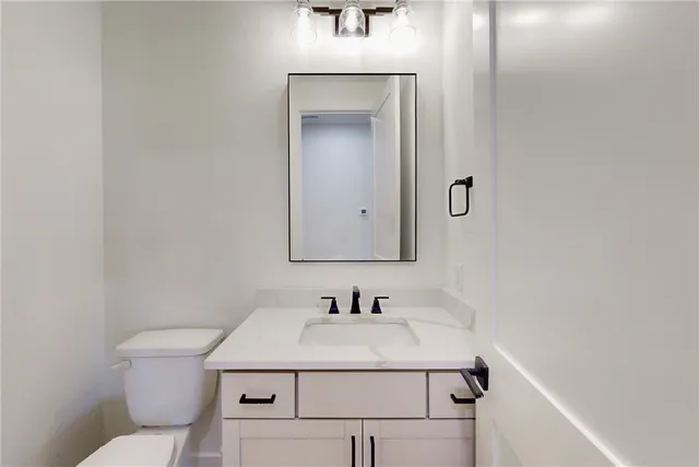 a bathroom with a sink toilet and mirror