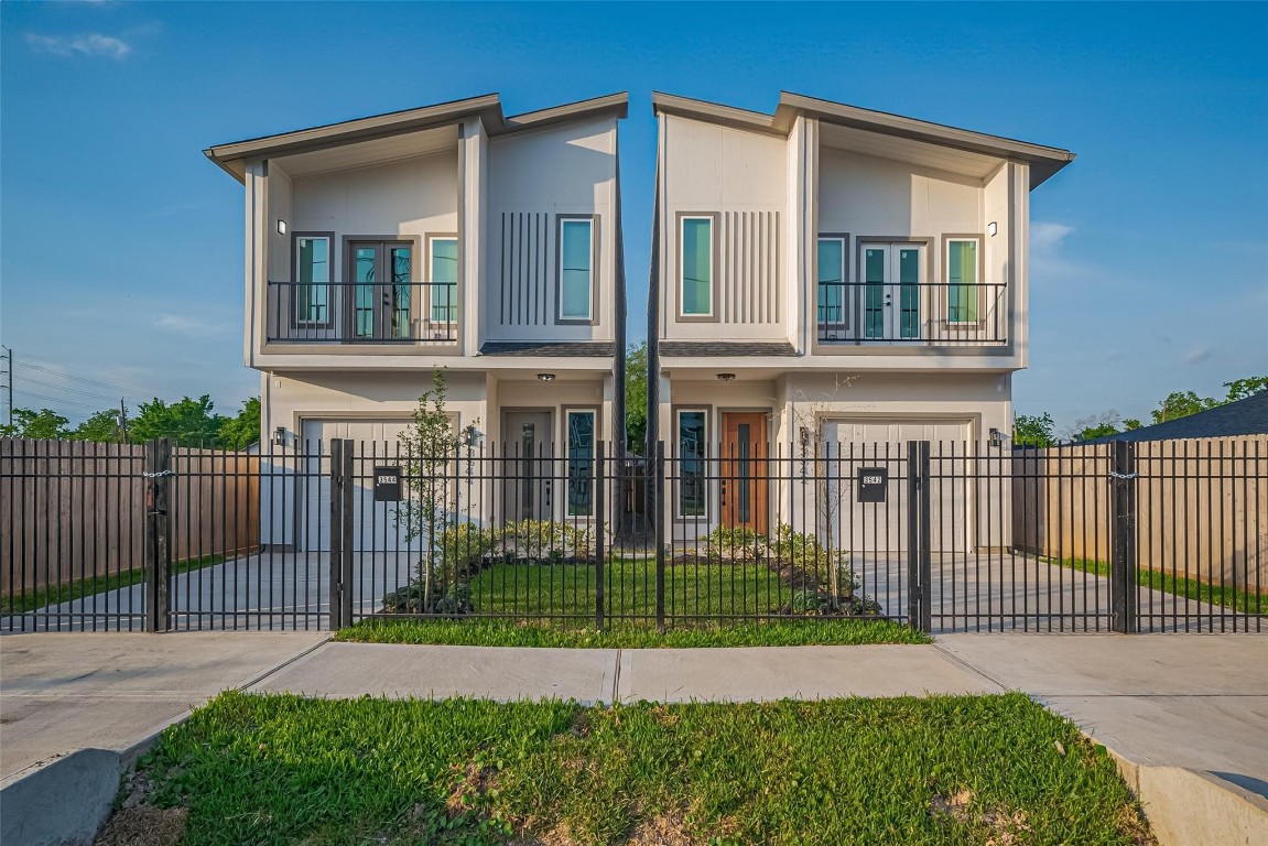 a view of a house with a small yard and wooden fence
