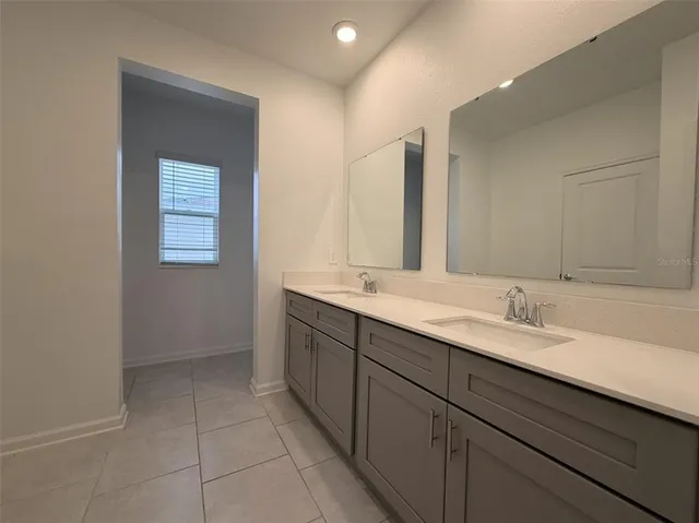 a bathroom with a double vanity sink and a mirror