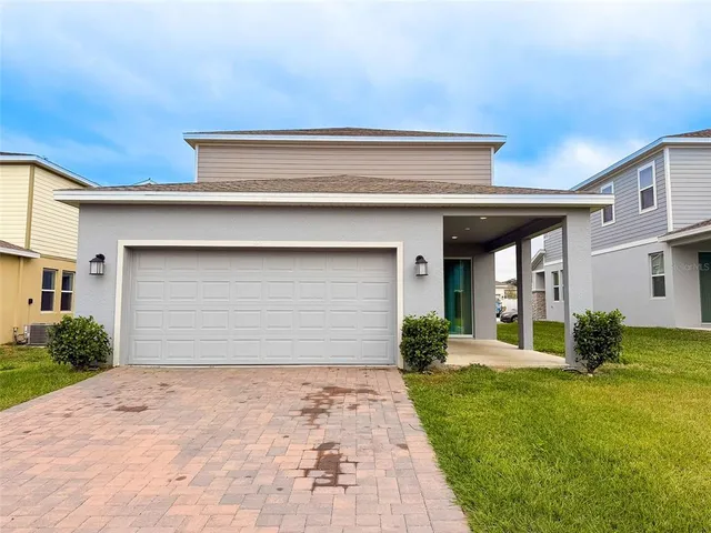 a front view of a house with a yard and garage