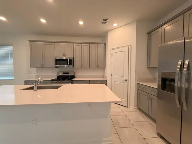 a large kitchen with cabinets and stainless steel appliances