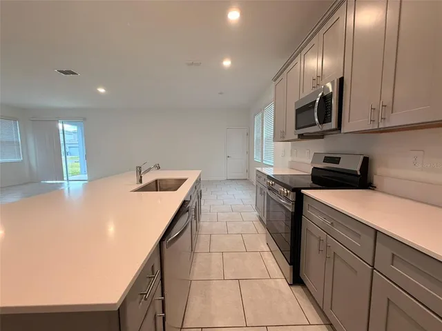 a kitchen with stainless steel appliances granite countertop a sink and dishwasher a stove top oven with wooden floor