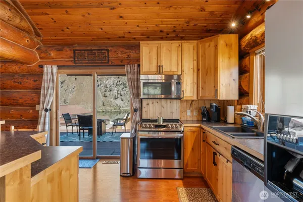a kitchen with stainless steel appliances granite countertop a stove a sink and a microwave